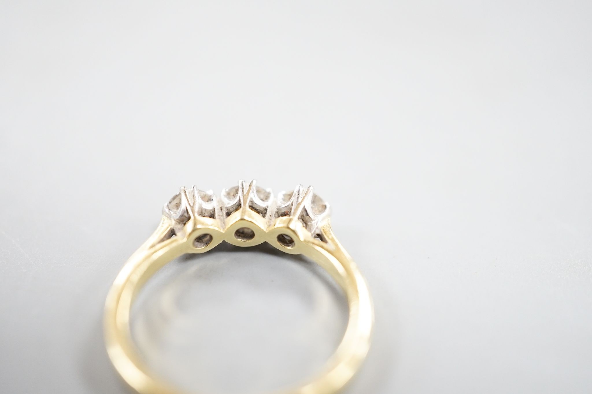 A modern 18ct gold and three stone diamond set ring, size J, gross weight 3 grams.